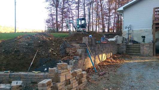 A brick wall being built in front of a house.