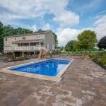 fiberglass swimming pool with paver patio