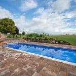 fiberglass swimming pool with paver patio