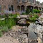 pond off of patio and outdoor living space